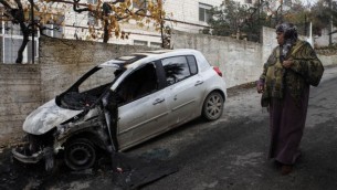 فلسطينية تقف امام سيارة حرقها المستوطنون في مخيم الجلبون شمال رام الله ٢٠١٣ (عصام ريماوي/ فلاش ٩٠)