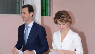 صورة للنشر صادرة عن صفحة الفيسبوك الرسمية للرئاسة السورية تظهر الرئيس السوري بشار الأسد (C) وزوجته أسماء الأسد (R ) يدلون بأصواتهم في مركز اقتراع في المالكي،  3 يونيو 2014،"AFP PHOTO / HO /THE OFFICIAL FACEBOOK PAGE OF THE SYRIAN PRESIDENCY"