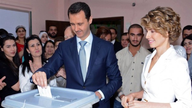 صورة للنشر صادرة عن صفحة الفيسبوك الرسمية للرئاسة السورية تظهر الرئيس السوري بشار الأسد (C) وزوجته أسماء الأسد (R ) يدلون بأصواتهم في مركز اقتراع في المالكي،  3 يونيو 2014،"AFP PHOTO / HO /THE OFFICIAL FACEBOOK PAGE OF THE SYRIAN PRESIDENCY"