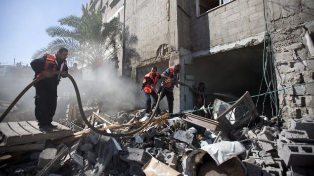 رجال الاطفاء الفلسطينيون في محاولة لاطفاء حريق شب في منزل دمر خلال غارة إسرائيلية، 16 يوليو 2014، في مدينة غزة. AFP PHOTO / MAHMUD HAMS رجال الاطفاء الفلسطينيون في محاولة لاطفاء حريق شب في منزل دمر خلال غارة إسرائيلية، 16 يوليو 2014، في مدينة غزة. AFP PHOTO / MAHMUD HAMS