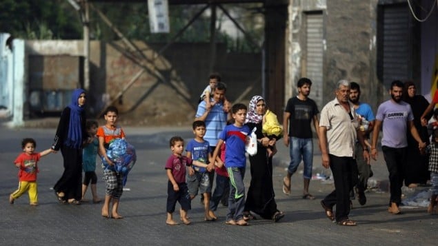 فلسطينيون يتركون بيوتهم في حي الشجاعية بعد القصف الإسرائيلي الثقيل 20 يوليو 2014 AFP PHOTO / MOHAMMED ABED
