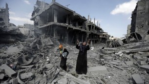 امرأة فلسطينية وسط المباني المدمرة في منطقة شمال بيت حانون في قطاع غزة  26 يوليو 2014. AFP PHOTO / MOHAMMED ABED