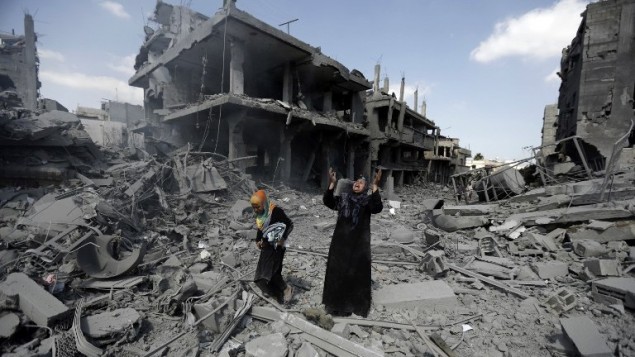 امرأة فلسطينية وسط المباني المدمرة في منطقة شمال بيت حانون في قطاع غزة  26 يوليو 2014. AFP PHOTO / MOHAMMED ABED