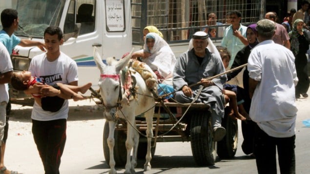 عائلات فلسطينية المنزاحة في طريقهم بحثا عن مكان أكثر أمنابينما يواصل الجيش الاسرائيلي  قصف منطقة خان يونس، في جنوب قطاع غزة  24 يوليو 2014Abed Rahim Khatib/Flash90