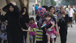 عائلات فلسطسنية تترك بيوتها بعد غارات اسرائيلية ليلية على مدينة غزة 10 يوليو 2014 (محمد عبد/ أ ف ب)