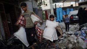 فلسطينيون من غزة ينقذون ما يستطيعون من بقايا منازلهم التي دمرتها غارة جوية اسرائيلية على مدينة رفح في جنوب قطاع غزة  26 أغسطس  2014. AFP PHOTO/ SAID KHATIB