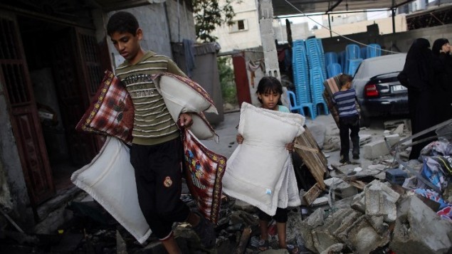 فلسطينيون من غزة ينقذون ما يستطيعون من بقايا منازلهم التي دمرتها غارة جوية اسرائيلية على مدينة رفح في جنوب قطاع غزة  26 أغسطس  2014. AFP PHOTO/ SAID KHATIB