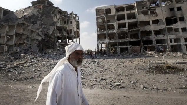 رجل فلسطيني في غزة يسير امام عمارات مهدمة 5 اغسطس، غزة ( AFP/ MAHMUD HAMS) رجل فلسطيني في غزة يسير امام عمارات مهدمة 5 اغسطس، غزة ( AFP/ MAHMUD HAMS)