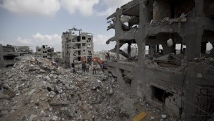 فلسطينيون بين انقاض المباني المدمرة في جزء من حي التفاح، مدينة غزة اثناء  وقف إطلاق النار  6 أغسطس 2014.  AFP PHOTO / MAHMUD HAMS