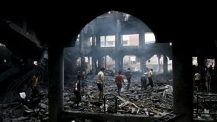 فلسطينيون يتفقدون أنقاض مركز تسوق دمر في اعقاب غارة اسرائيلية ليلية، مدينة غزة جنوب مدينة رفح، 24 أغسطس 2014 Abed Rahim Khatib/Flash90