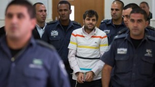 رجال الشرطة يرافقون يوسف حاييم بن دافيد, أحد المشتبه بهم اليهود في قتل القاصر محمد ابو خضير في المحكمة القطرية في القدس 6 أغسطس (يوناتان سنايدل/ فلاش 90)