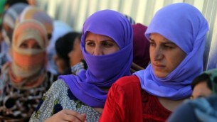 نساء يزيديات عراقيات يقفن من أجل الحصول على الطعام في مخيم بالقرب من  نهر دجلة في محافظة دهوك غرب كردستان، حيث لجأوا بعد فرارهم من الدولة الإسلامية 13 أغسطس 2014  AFP/AHMAD AL-RUBAYE