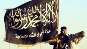 صورة مأخوذة من شريط فيديو  تم تحميله في 7 سبتمبر 2013 من قبل جماعة الدولة الاسلامية يظهر أحد الأعضاء مع راية الجماعة خلال عرض في مكان لم يكشف عنه في سوريا.   AFP PHOTO / HO / AHRAR AL-SHAM