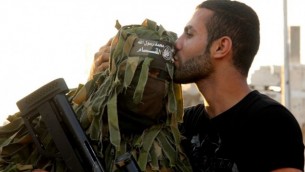 رجل فلسطيني يقبل جبين قناص من كتائب عز الدين القسام على انقاض حي الشجاعية في شمال قطاع غزة، 27 أغسطس 2014    Abed Rahim Khatib/Flash90
