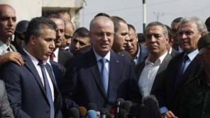 رئيس الوزراء الفلسطيني رامي حمد الله  يلقي خطابا خلال جولة لبعض المناطق الأكثر تضررا من حرب ال 50 يوما بين اسرائيل وقطاع غزة في شهري يوليو وأغسطس، 9 أكتوبر 2014    Said Khatib/AFP