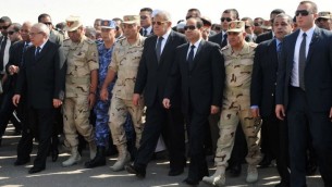 صورة مقدمة من مكتب الرئاسة المصرية 25 أكتوبر 2014 ، تظهر الرئيس المصري عبد الفتاح السيسي ورئيس الوزراء إبراهيم محلب ، أثناء جنازة 30 جندي قتلوا في اليوم السابق في سيناء، في القاعدة الجوية العسكرية ألماظة في القاهرة  AFP PHOTO/ HO/ EGYPTIAN PRESIDENCY