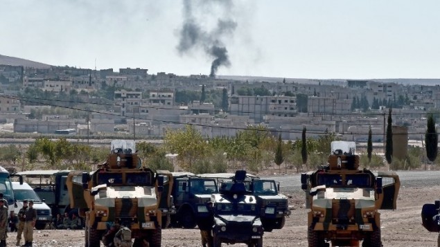 الدخان يرتفع من البلدة السورية عين العرب،  5 أكتوبر 2014.  AFP PHOTO / ARIS MESSINIS
