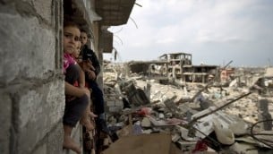 اطفال فلسطينيون يجلسون على حافة نافذة من مبنى دمر جزئيا في حي التفاح، شرق مدينة غزة 11 أكتوبر 2014 (AFP PHOTO / MAHMUD HAMS)