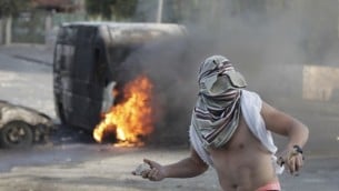 ملثم فلسطيني يلقي حجارة أثناء اشتباكات مع قوات الأمن الإسرائيلية في القدس الشرقية، 30 أكتوبر 2014 AFP/Ahmad Gharabli