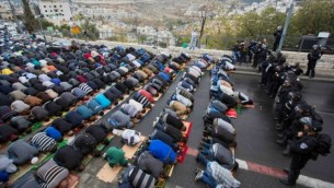 شباب فلسطينيون، الذين منعتهم الشرطة الاسرائيلية من الصلاة في الحرم القدسي الشريف، يصلون وطوق الشرطة حولهم في حي القدس الشرقية  وادي الجوز، 31 أكتوبر 2014  Yonatan Sindel/Flash90