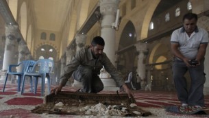 فلسطينيون ينظفون الحطام داخل المسجد الأقصى،  5 نوفمبر 2014 عقب اشتباكات بين رماة الحجارة الفلسطينيين وقوات الأمن الإسرائيلية AFP PHOTO/AHMAD GHARABLI