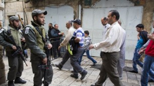 فلسطينيون في  طريقهم إلى المسجد الأقصى في مجمع الحرم القدسي الشريف لأداء صلاة الجمعة، والشرطة الاسرائيلية تراقب الاوضاع  14 نوفمبر 2014  (Yonatan Sindel/Flash90)