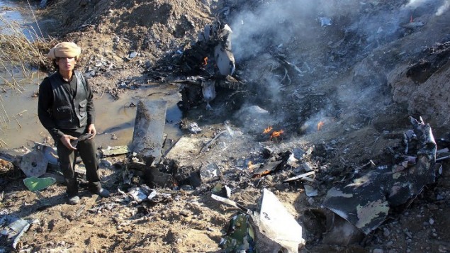 24 ديسمبر 2014 مقاتل الدولة الإسلامية يجمع قطع من بقايا طائرة حربية أردنية في منطقة الرقة في سوريا. اسرت  الدولة الإسلامية طيار أردني بعد اسقاط طائرته الحربية . AFP PHOTO / RMC / STR