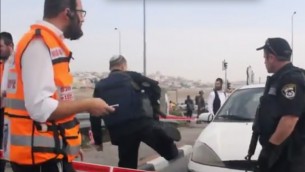 قوات الأمن ومسعفون في غوش عتصيون بعد ان سكب رجل فلسطيني مادة حمضية على الأسرة، مما أدى إلى إصابة خمسة، 12 ديسمبر 2014  (من شاشة اليوتوب)
