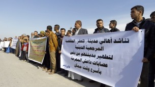 نازحون عراقيون من الموصل ومدينة تلعفر يحتجون في مدينة النجف بجنوب العراق 25 يناير 2015 ضد ظروفهم المعيشية، وطالبوا كبير رجال الدين الشيعة في العراق آية الله العظمى علي السيستاني للضغط على الحكومة المركزية لتحرير مناطقهم من الدولة الإسلامية (IS) AFP PHOTO / HAIDAR HAMDANI
