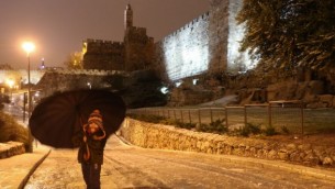 فتاة صغيرة  مع مظلة بالقرب من أسوار البلدة القديمة في القدس خلال العاصفة  07 يناير كانون الثاني عام 2015  (فلاش 90)