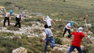 صورة توضيحية لمستوطنين ملثمين يتبادلون رمي الحجارة مع فلسطينيين في الضفة الغربية 3 مايو 2013 (Issam Rimawi/FLASH90)