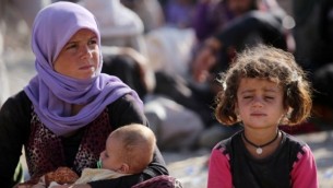 وقالت امرأة عراقية اليزيدية تجلس مع أطفالها في مخيم لاجئين بالقرب من نهر دجلة في محافظة دهوك غرب كردستان، حيث لجأوا بعد فرارهم من تقدم  الدولة الإسلامية في العراق 13 أغسطس، 2014  AFP/AHMAD AL-RUBAYE