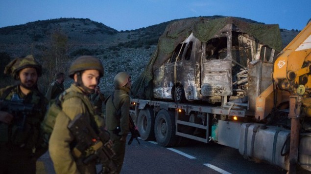 جنود اسرائيليون ينقلون مركبة محروقة من موقع هجوم حزب الله في مزارع شبعا في 28 يناير 2015 (AFP/MENAHEM KAHANA)