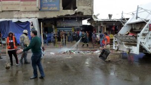 العراقيون ينظفون الشوارع بعد انفجار في مطعم في بغداد الجديدة، 7 فبراير 2015 (SABAH ARAR / AFP)