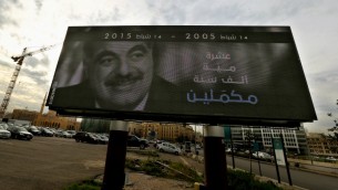 صورة في مركز بيروت تظهر رئيس الوزراء اللبناني الراحل رفيق الحريري بالذكرى العاشرة لاغتياله بجانب الشعار "عشرة، مية، الف سنة مكملين"، 6 فبراير 2015 (JOSEPH EID / AFP)