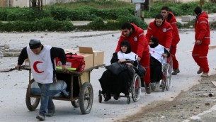 عاملو الهلال الأحمر ينقلون مصابين من مناطق المعارضة الى مناطق النظام في مدينة حلب السورية، 4 فبراير 2015 (BARAA AL-HALABI / AFP)