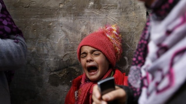 صبي فلسطيني يبكي أثناء تشييع جنازة طفل عمره 9 اشهر، بعد وفاته في حريق جراء تماس كهربائي، في مدرسة للامم المتحدة تستخدم كمأوى للفلسطينيين الذين دمرت منازلهم  في القصف الإسرائيلي  صيف 2014،  بيت حانون ، غزة 17 فبراير، 2015. AFP PHOTO / MOHAMMED ABED