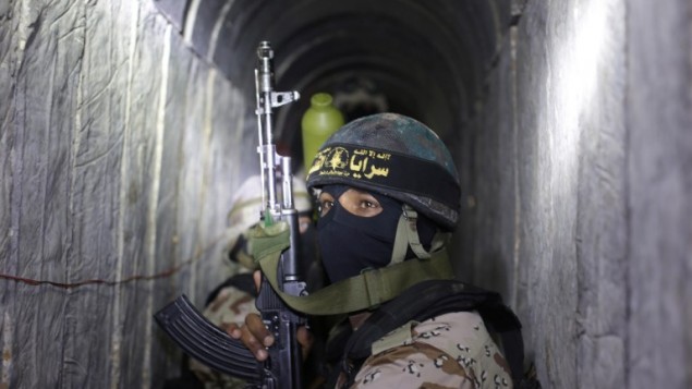 مسلحون فلسطينيون من الجناح المسلح للجهاد الإسلامي، سرايا القدس، داخل نفق  يُستخدم لنقل الصواريخ والقذائف استعدادا للصراع القادم مع إسرائيل، خلال مشاركتهم في تدريب عسكري جنوب قطاع غزة في 3 مارس، 2015. (AFP/MAHMUD HAMS)