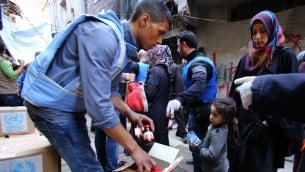 لاجئون فلسطينيون ينتظرون في مخيم اليرموك جنوب دمشق للحصول على المساعدات التي توزعها وكالة الامم المتحدة لاغاثة وتشغيل اللاجئيين الفلسطينيين (اونروا)  10 مارس 2015  AFP PHOTO / YOUSSEF KARWASHAN