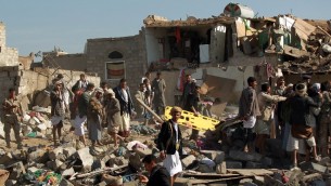 البحث عن الناجين بعد غارة سعودية بالقرب من مطار صنعاء في اليمن، 26 مارس 2015 (MOHAMMED HUWAIS / AFP)