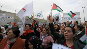 نساء فلسطينيات يحيون يوم المرأة العالمي بمظاهرة في حاجز قلنديا، 8 مارس 2015 ( Issam Rimawi/Flash90)