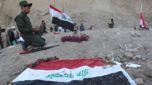 مقاتل عراقي شيعي يصلي في موقع يعتقد انه مقبرة جماعية لضحايا مجزرة سبايكر في مدينة تكريت العراقية، 4 ابريل 2015 (AHMAD AL-RUBAYE / AFP)