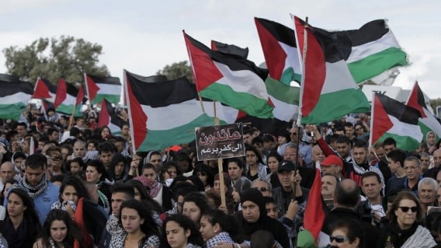 الالاف من مواطني اسرائيل العرب يحملون الأعلام الفلسطينية خلال مسيرة العودة السنوية من اجل حق العودة للاجئين الفلسطينيين الذين فروا من ديارهم أو طردوا خلال حرب عام 1948. مسيرة هذا العام الى قرية الحدثة بالقرب من طبريا في شمال إسرائيل،  23 أبريل عام 2015. AFP PHOTO / AHMAD GHARABLI