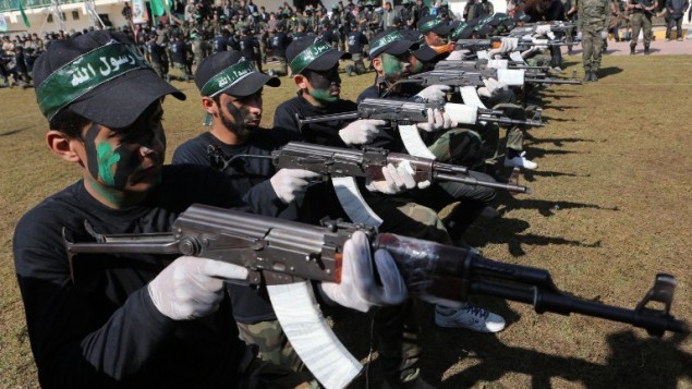 صورة  التُقطت  في 29 يناير، 2015، والتي يظهر فيها فتيان فلسطينيون يقومون بعرض مهاراتهم خلال حفل تخريج ضمن مخيم تدريبي تنظمه حركة حماس في خان يونس بجنوب قطاع غزة. (AFP photo/Said Khatib)