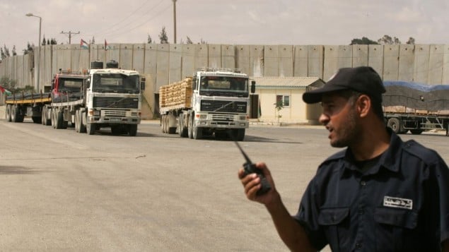 شرطي فلسطيني تابع لحماس يشرف على شاحنات تدخل مواد بناء الى قطاع غزة عن طريق معبر كرم ابو سالم، 22 سبتمبر 2013 (Abed Rahim Khatib/Flash90)