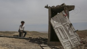 طفلة فلسطينية تجلس بالقرب من بيت خارج في قرية المفكرة الفلسطينية، جنوبي الخليل في الضفة الغربية، 23 ابريل 2014 (Hadas Parush/Flash90