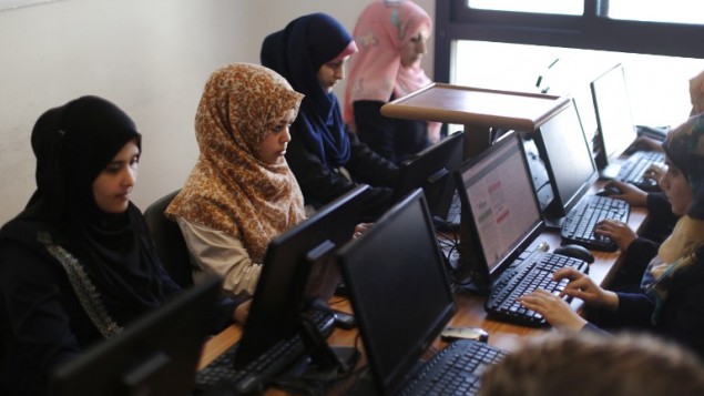 نساء فلسطينيات يعملن امام الحواسيب في شركة يونيت وان في مدينة غزة، 18 ابريل 2015 (MAHMUD HAMS / AFP)