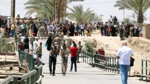 سكان في مدينة الرمادي، الذين فروا من منازلهم في 16مايو، 2015 مع تضييق مقاتلي تنظيم ’الدولة الإسلامية’ الحصار على آخر معاقل الحكومة في عاصمة محافظة الأنبار، في انتظار عبور جسر بزيبز على الحدود الجنوبية الغربية لبغداد مع محافظة الأنبار. جهاديو ’الدولة الإسلامية’ سيطروا على كل الطرق التي تربط المحافظة بالعاصمة العراقية. (AFP/ SABAH ARAR)
