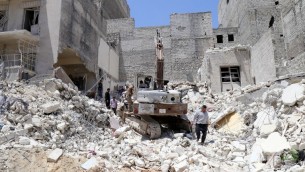 السكان يتفحصون الحطام بعد غارات من قبل قوات النظام في مدينة حلب في سوريا، 24 مايو 2015 (BARAA AL-HALABI / AFP)