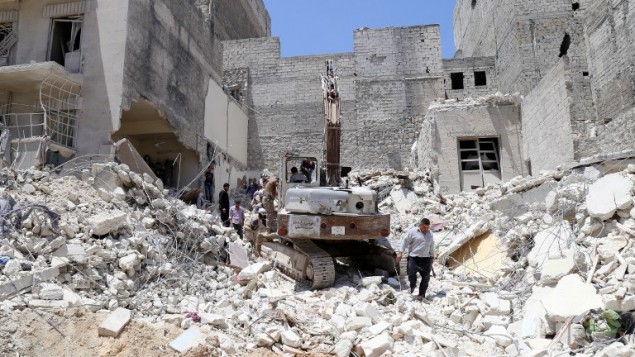 السكان يتفحصون الحطام بعد غارات من قبل قوات النظام في مدينة حلب في سوريا، 24 مايو 2015 (BARAA AL-HALABI / AFP)